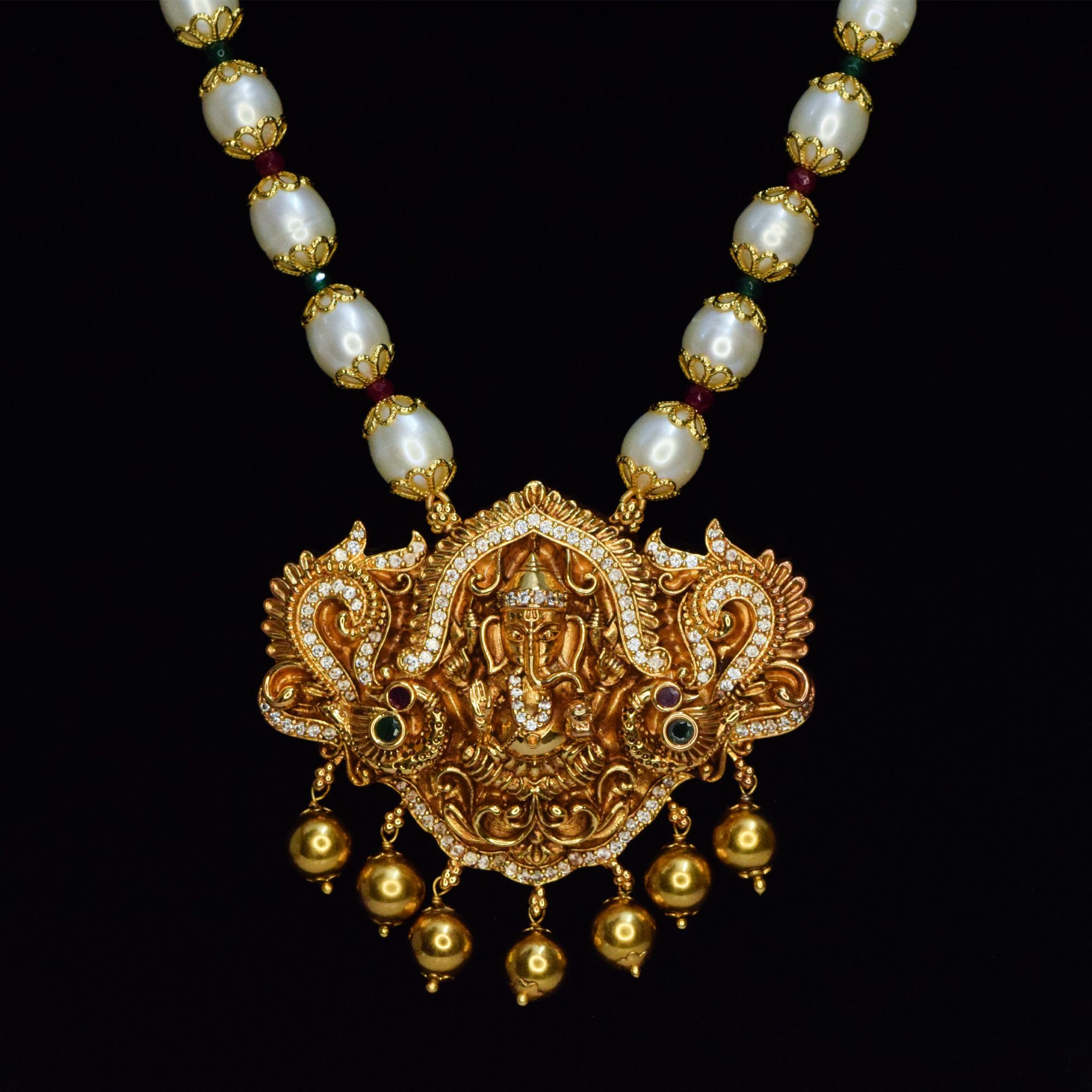 Auspicious golden finish Lord Ganesha pendant strung onto a long & radiant 8.5mm oval white pearls necklace -close up
